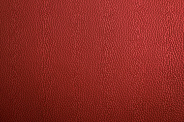 Leather texture close up. Red fashionable background, top view. Stylish coral wallpaper with rough surface.