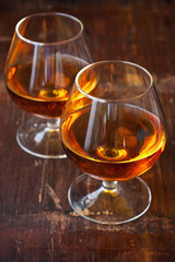 Two glasses of brandy or cognac on  dark table