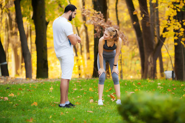 Fitness. Personal Trainer Takes Notes While Woman Exercising Outdoor