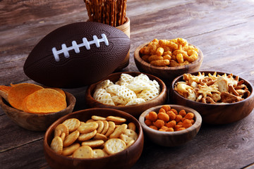 Chips, salty snacks, football on a table. Great for Bowl Game snack projects.