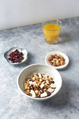 Bowl of granola with nuts, cranberry and cocoanut. Concept for a tasty and healthy meal. Stone / wooden background. 