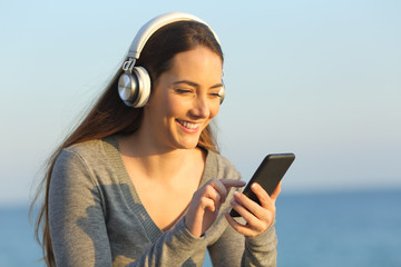 Happy woman listening to music using smart phone