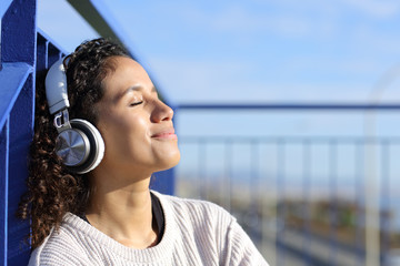 Relaxed latina girl listening to music outdoors