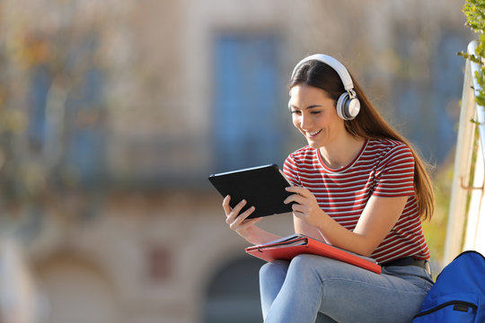 Happy student with headphones and tablet e learning
