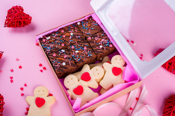 A set of delicious treats in a box with tape. A Valentine's Day gift. Pink background