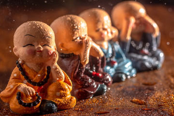Three baby laughing buddhas sitting in the three monkeys format with another fourth baby laughing...