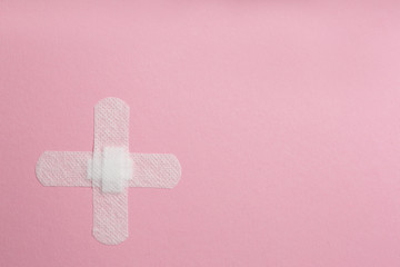 Sticking plasters on pink background, top view. Space for text