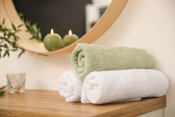 Fresh towels on wooden table in bathroom