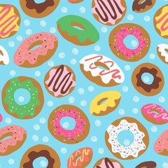 Seamless vector repeat pattern with colorful donuts with sprinkles and icing tossed on a blue background with polka dots in the background