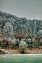 winter football field with frosted mountains in background and goals