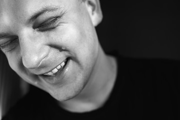 Stylische Aufnahme eines vor Lachen weinenden jungen Mannes