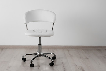 Chair with pins near white wall, space for text. Hemorrhoids concept