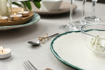 Obraz na płótnie Canvas Elegant spoon tied with twine on white wooden table, closeup. Festive setting