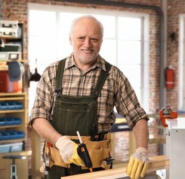 Senior happy handyman working at DIY workshop