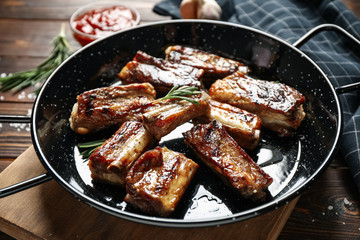 Delicious grilled ribs with rosemary on wooden table