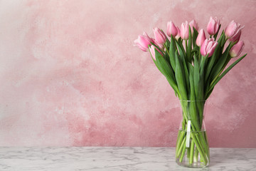 Beautiful pink spring tulips on marble table. Space for text