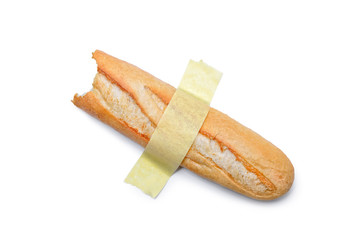 A half-eaten loaf of bread taped to a white surface. Modern pop-art.