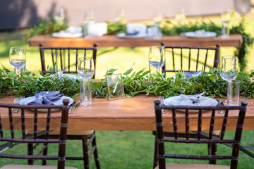 Preparing for an open-air party. Decorated with fresh flowers served tables. Table number. Decoration Details