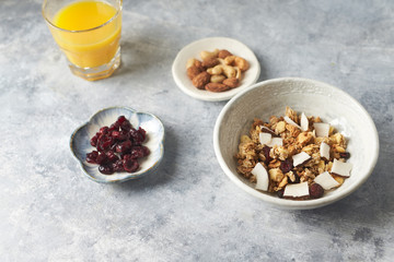 Bowl of granola with nuts, cranberry and cocoanut. Concept for a tasty and healthy meal. Stone / wooden background. 