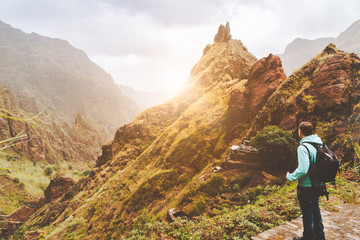 Santo Antao Island, Cape Verde. Traveler man with camera on sunset in front of mountain ridge and ravine on the cobbled path to Xo-Xo Valley