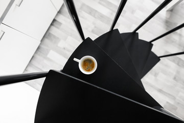top view of a cup of coffee that stands on the steps. Morning aromatic coffee.