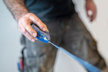 Handwerker markiert den Estrich mit einem Schnurschlag aus blauem Kreidepulver