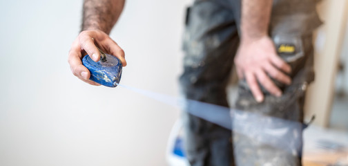 Handwerker markiert den Estrich mit einem Schnurschlag aus blauem Kreidepulver