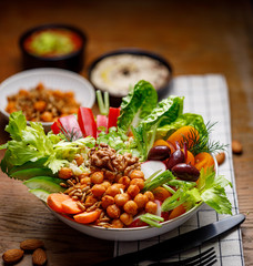 Buddha bowl, healthy salad with various vegetables, seeds and herbs on a wooden table, close up. The concept of vegan healthy eating