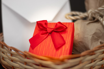 Obraz premium dos regalos y sobre de san valentín en corazón de mimbre fondo negro 