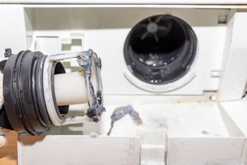 Broken pump of washing machine's caused by dirty clogged drain pump filter close up, clean and...