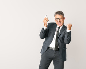 Happy businessman with mobile phone on white background