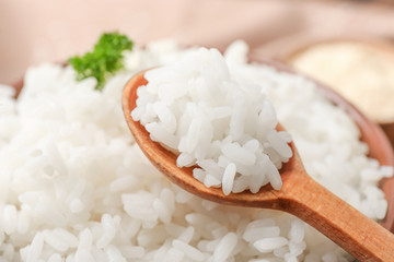 Spoon and bowl with boiled rice, closeup