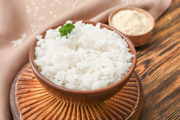 Boiled rice in bowl on wooden table