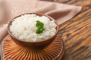 Boiled rice in bowl on wooden table