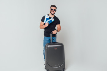 Man traveler with suitcase on white background posinf with two ticket for he and someone.