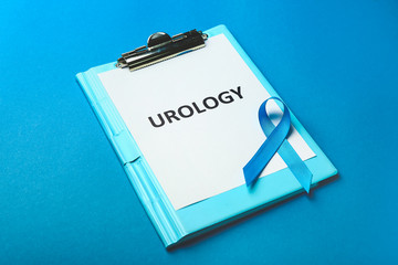 Blue ribbon with clipboard on color background. Prostate cancer concept