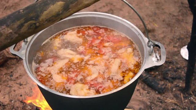 Big couldron with lagman food on open fire. Natural meat and vegetables food on nature