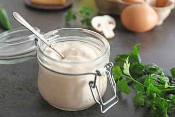 Jar of tasty sauce on dark background