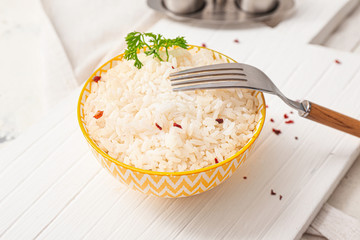 Bowl with boiled rice and spices on table