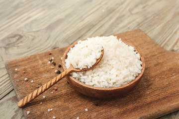 Plate with boiled rice and spices on wooden table