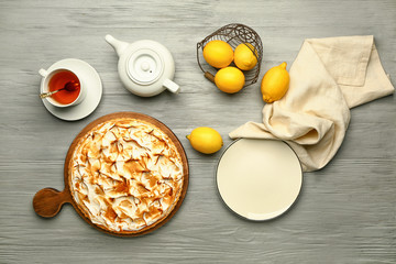 Tasty lemon pie with tea on wooden table
