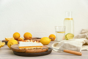 Plate with piece of tasty lemon pie on table