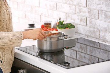 Woman preparing tasty rice in kitchen