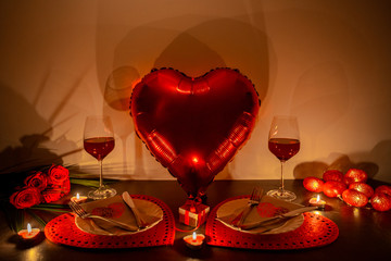 Valentines day dinner with burning candles and balloon