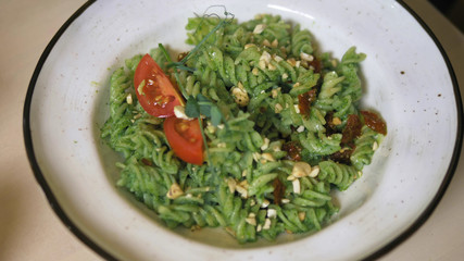 fashionable design food. vegetarian pasta with green sauce and cashew nuts