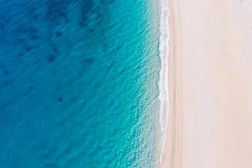 Zelfklevend Fotobehang Top-down aerial view of a white sandy beach on the shores of a beautiful turquoise sea. © MZaitsev