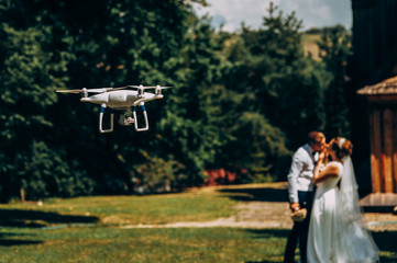 piloting drone taking pictures of wedding couple in nature - Powered by Adobe