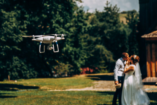 piloting drone taking pictures of wedding couple in nature
