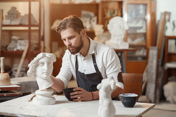Skillful sculptor makes professional restauration of gypsum sculpture of woman's head at the...