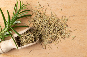 Fototapeta na wymiar Pile of Dry Rosemary on Wooden Background Top View